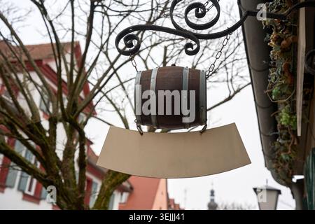 Signe de magasin de baril en bois vintage vierge accroché sur un support en fer forgé orné sur une rue de la ville. Banque D'Images