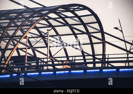 Pont supérieur contemporain avec éléments géométriques et éclairage au néon bleu au crépuscule Banque D'Images