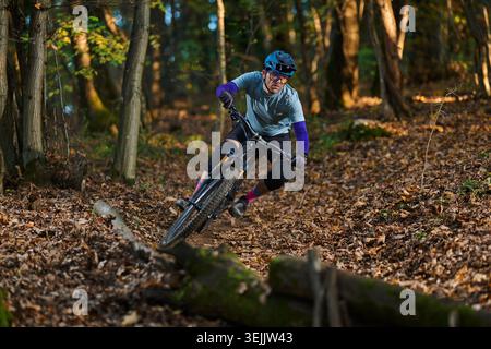 Mountain Biker navigue sur Forest Trail dans les couleurs et l'équipement d'automne Banque D'Images