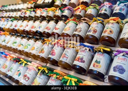 Rangées de pots de confiture colorés de Staud exposés sur les étagères d'un marché. Banque D'Images