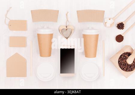 Fond décoratif pour restaurant et café - deux tasses en papier blanc, téléphone, étiquette, coeur, grains de café sur boa en bois blanc Banque D'Images