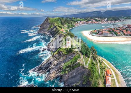 Vue aérienne des falaises côtières spectaculaires avec chapelle, plage de sable et ville colorée, Ribadesella, Asturies, Espagne Banque D'Images