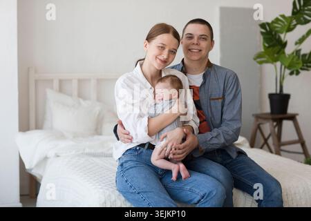 Jeunes parents tenant leur fille nouveau-née à la maison jeunes parents tenant leur fille nouveau-née à la maison Banque D'Images