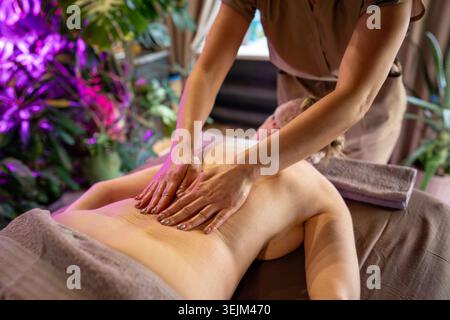 Femme recevant le massage du corps de Lady masseuse, masseur professionnel massant et relaxant les muscles tendus du bas du dos pour femme Banque D'Images