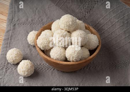 Pile de bonbons à la noix de coco, balle de coco. Boule de truffe blanche, ladoo indien ou laddu avec crème sucrée et flocons de noix de coco, dessert praliné maison, barfi en WO Banque D'Images