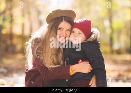 Portrait de maman avec un fils enfant marchant dans le parc d'automne Banque D'Images