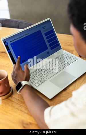 Ordinateur portable blanc affichant le contenu de marketing numérique de style chat sur une table en bois à côté d'une tasse en céramique. Espace de travail, maison, bureau, minima Banque D'Images