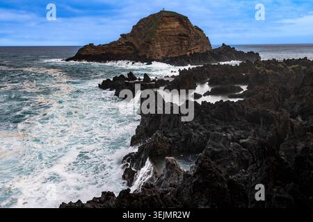 Côte rocheuse par temps orageux, Porto Moniz, côte nord-ouest, petite île au large Ilheu mole, île de Madère, Portugal Banque D'Images