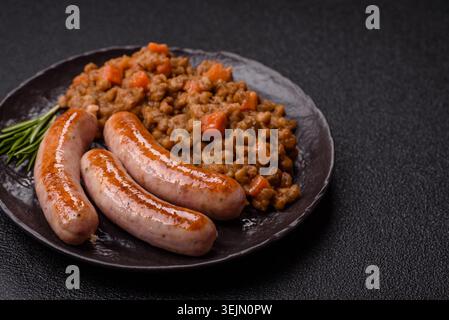 Ragoût de lentilles, carottes et tomates avec saucisses, un plat européen. Lentilles avec saucisses Banque D'Images