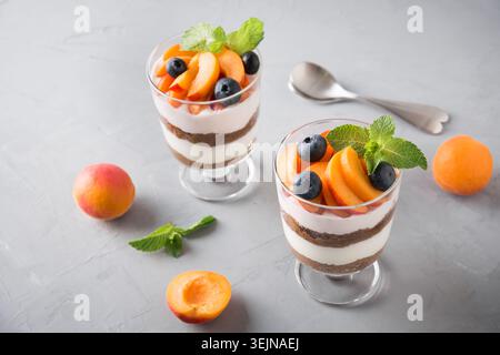 Bagatelle d'abricot, biscuit au chocolat, dessert en couches avec baies fraîches et fromage à la crème doux. Banque D'Images