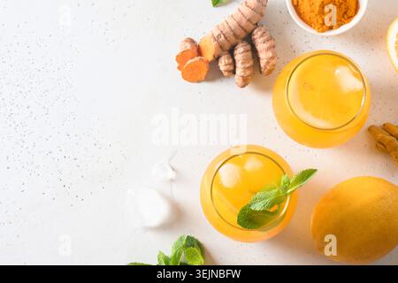 Jamu boisson indonésienne à base de plantes avec des ingrédients naturels curcuma, gingembre sur fond blanc. Espace pour le texte. Vue de dessus. Banque D'Images