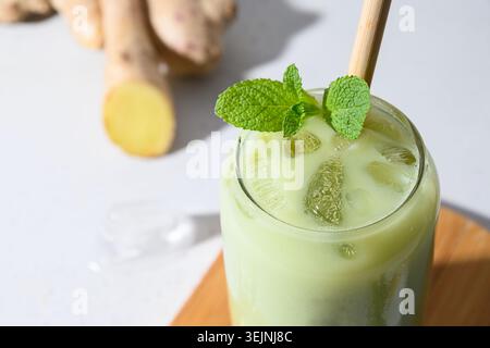 Thé vert glacé au matcha latte sur une table blanche. Gros plan. Banque D'Images