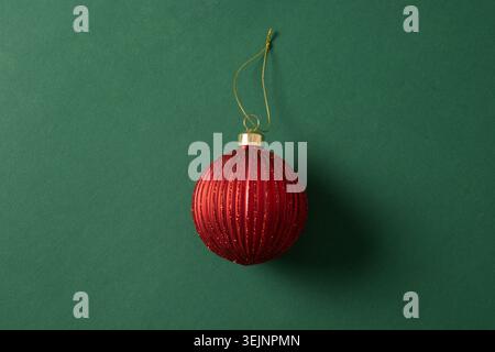 Boule de Noël rouge sur fond vert. Vue de dessus. Banque D'Images