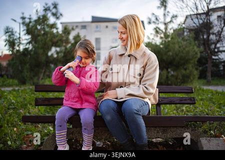 Mère et fille jouant avec le kaléidoscope dans le parc Banque D'Images