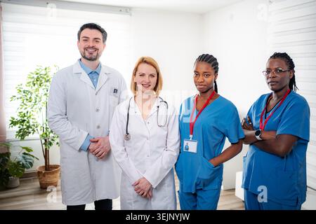 Divers professionnels de la santé font équipe souriante dans le hall de la clinique Banque D'Images