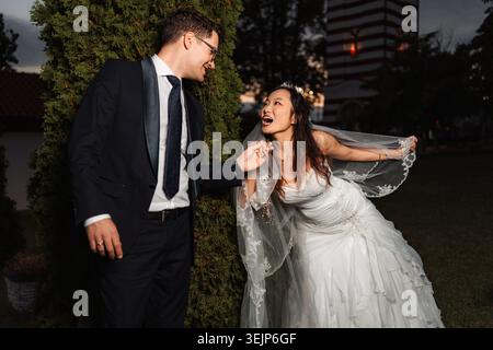 Couple interracial célébrant le jour du mariage avec joie Banque D'Images