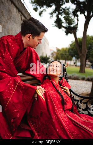 Couple interracial célébrant le mariage traditionnel chinois dans le parc Banque D'Images