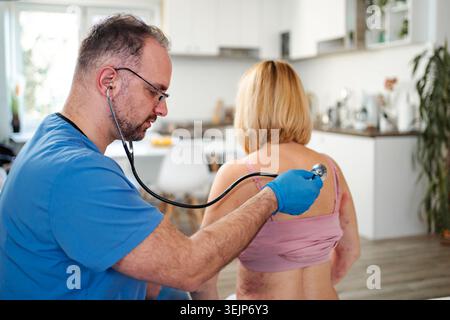 Médecin masculin examinant une femme avec une éruption cutanée sur le dos Banque D'Images