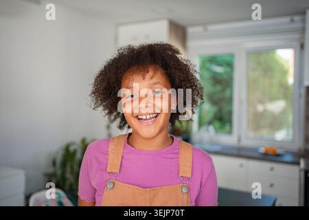 Heureuse fille afro-américaine souriante à la maison Banque D'Images