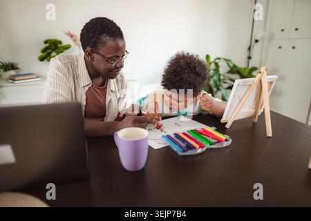 Grand-mère et petit-fils dessinant ensemble à la maison Banque D'Images