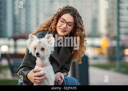 Jeune femme profitant du temps avec son chien animal de compagnie mignon Banque D'Images