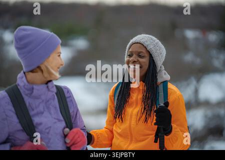 Deux amies féminines heureuses profitant de la randonnée hivernale ensemble Banque D'Images