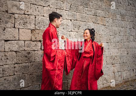 Couple multiculturel célébrant l'amour dans une tenue de mariage chinoise traditionnelle Banque D'Images