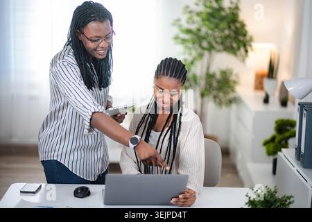 Femmes d'affaires collaborant sur ordinateur portable dans le bureau moderne Banque D'Images