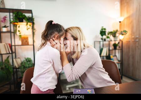 Mère partage un moment tendre avec sa fille dans un cadre intérieur cosy Banque D'Images