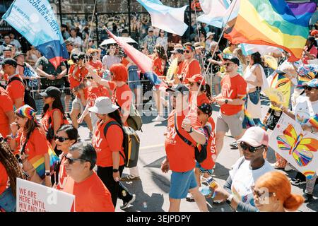 Toronto, Canada - 29 juin 2025 : foule porteuse de drapeaux avançant ensemble Banque D'Images
