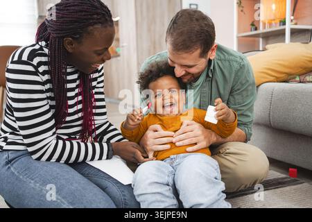 Joyeuse famille multiraciale profitant de moments ludiques à l'intérieur ensemble Banque D'Images