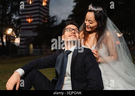 Couple interracial célébrant mariage dans le parc pendant la soirée Banque D'Images