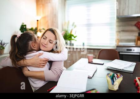 Embrassement amoureux entre mère et fille à la maison pendant l'après-midi Banque D'Images