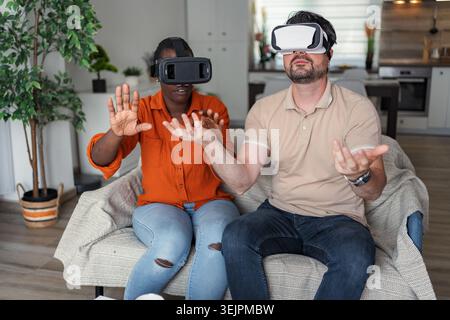 Couple explorant la réalité virtuelle en utilisant des casques vr à la maison Banque D'Images