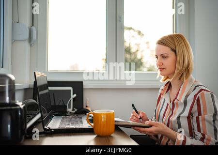 Femme travaillant à la maison au bureau regardant concentré Banque D'Images