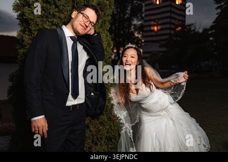 Couple interracial célébrant le jour de mariage dans le jardin Banque D'Images