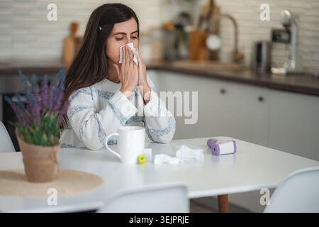 Jeune femme souffrant de rhume ou d'allergie soufflant le nez Banque D'Images