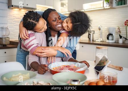 Aimer la famille cuisiner la pizza ensemble dans la cuisine domestique Banque D'Images