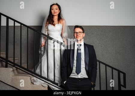 Couple de mariage interracial posant sur un escalier Banque D'Images