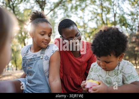 Mère et enfants jouant dans le parc Banque D'Images