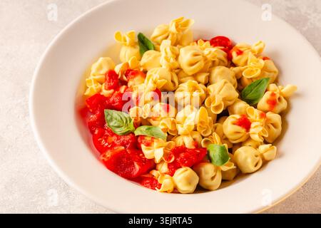 Pâtes italiennes farcies. Sacсhettini pâtes dans une assiette avec sauce tomate. Banque D'Images