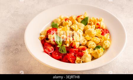 Pâtes italiennes farcies. Sacсhettini pâtes dans une assiette avec sauce tomate. Banque D'Images