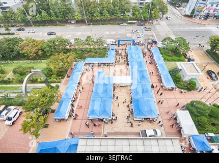 Ce cliché à grand angle capture un marché d'automne en plein air à Ongjin Gun. Les cabines bleues attirent les visiteurs à la recherche de produits locaux spécialisés dans une place. Banque D'Images