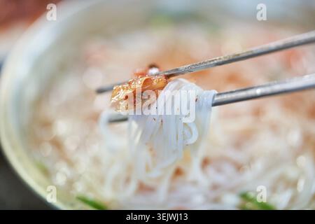Janchi-guksu sert des nouilles chaudes dans un bouillon salé, contrastant avec le bibim-guksu doux, épicé et froid. Les deux offrent des saveurs coréennes authentiques. Banque D'Images