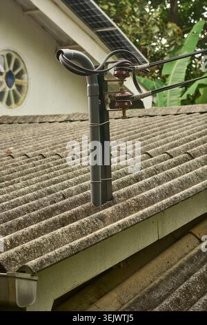 mât électrique d'énergie solaire sur toit ondulé, isolants et fils noirs sur fond de toit, soft focus gros plan et espace de copie, énergie renouvelable Banque D'Images