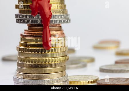 Du sang comme de la peinture coulant sur la pile de centimes d'euro Banque D'Images