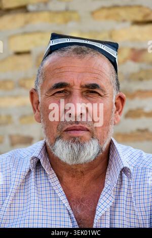 Khiva, Ouzbékistan - 9 avril 2026 : homme ouzbek barbu portant une casquette Doppi traditionnelle à Khiva, Ouzbékistan Banque D'Images