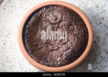 Gâteau au chocolat noir dans un pot en argile sur une assiette Banque D'Images