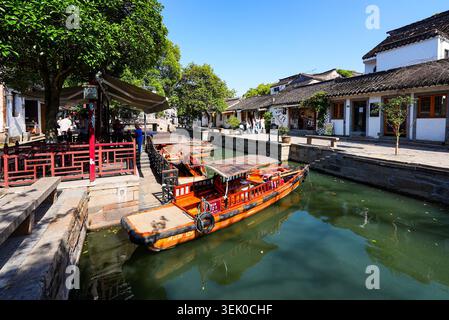 Bateaux touristiques traditionnels en bois amarrés le long d'un canal pittoresque bordé de maisons historiques dans la ville d'eau de Tongli, Jiangsu, Chine Banque D'Images
