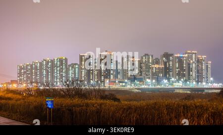 Vue de nuit des immeubles d'appartements de grande hauteur vus de la piste cyclable Musimcheon un jour de pluie, Cheongju, Corée du Sud Banque D'Images